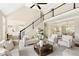 Elegant living room with a fireplace, staircase, and lots of natural light from a large window at 6185 Deerwoods Trl, Alpharetta, GA 30005