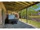 Relaxing covered patio featuring a modern hot tub overlooking the lush backyard and serene lake at 6185 Deerwoods Trl, Alpharetta, GA 30005