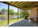 Covered patio perfect for entertaining, offering serene views of the lake and beautifully landscaped yard at 6185 Deerwoods Trl, Alpharetta, GA 30005