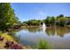 Scenic pond view with a fountain and dock, surrounded by lush greenery and trees at 6185 Deerwoods Trl, Alpharetta, GA 30005