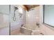 Bright bathroom featuring tiled shower-tub combo, window, and mosaic tiled floor at 1661 La France Ne St # 221, Atlanta, GA 30307
