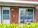 Cozy patio area with comfortable seating, set against a brick facade with a large window and greenery at 1661 La France Ne St # 221, Atlanta, GA 30307