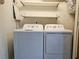 Functional laundry room featuring a side-by-side washer and dryer with overhead shelving at 1661 La France Ne St # 221, Atlanta, GA 30307