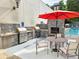 Outdoor grill area with built-in grill, stone fireplace, dining table and lounge chairs by the pool at 1661 La France Ne St # 221, Atlanta, GA 30307