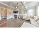 Comfortable living room with a fireplace, TV, decorative art, a modern ceiling fan, and large windows at 197 Hickory Pointe Dr, Acworth, GA 30101