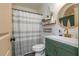 Charming bathroom with green vanity, stylish round mirror, and decorative shelves for a spa-like feel at 2681 Linnwood Se Dr, Smyrna, GA 30080