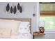 Bright bedroom showcasing a decorative wall hanging, stylish window shade, and cozy bedside decor at 2681 Linnwood Se Dr, Smyrna, GA 30080