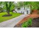 Exterior view of a grey painted brick home showcasing a long driveway and well maintained lawn at 2681 Linnwood Se Dr, Smyrna, GA 30080