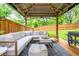 Inviting covered patio featuring a cozy seating area, grill, and wooden deck surrounded by a privacy fence at 2681 Linnwood Se Dr, Smyrna, GA 30080