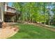 Lush backyard featuring a deck, patio, mature trees, and grassy lawn perfect for outdoor activities at 320 Rossiter Rdg, Alpharetta, GA 30022