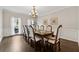 Formal dining room featuring hardwood floors, elegant chandelier, and ample seating at 320 Rossiter Rdg, Alpharetta, GA 30022
