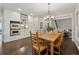 Bright dining area with wood table and chairs, cabinetry, stainless oven, and view into living room at 320 Rossiter Rdg, Alpharetta, GA 30022