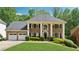 Stately brick home featuring a three-car garage and a beautifully manicured lawn with lush landscaping at 320 Rossiter Rdg, Alpharetta, GA 30022