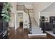 Inviting foyer with hardwood floors and staircase with decorative carpet runner at 320 Rossiter Rdg, Alpharetta, GA 30022