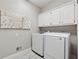 Bright laundry room with white cabinets, modern washer and dryer, and stylish decor at 320 Rossiter Rdg, Alpharetta, GA 30022