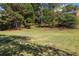 Expansive backyard with a gentle slope, mature trees, and shade, ideal for outdoor activities at 9770 Coleman Rd, Roswell, GA 30075