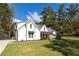 Stunning two-story white home with a lush green lawn and beautiful landscaping, and black trim around the windows at 9770 Coleman Rd, Roswell, GA 30075