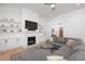 Comfortable living room featuring a fireplace, built-in shelving, and a cozy gray sectional sofa at 9770 Coleman Rd, Roswell, GA 30075