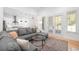 Open-concept living room flowing into the kitchen, featuring a comfortable gray sectional sofa and natural light at 9770 Coleman Rd, Roswell, GA 30075