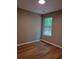 Bright bedroom with wood floors, neutral walls, and a window overlooking a green outdoor space at 1356 Ambercrest Way, Austell, GA 30168