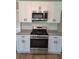White kitchen with stainless steel microwave and range at 1356 Ambercrest Way, Austell, GA 30168