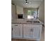 Bright kitchen island featuring granite countertops, stainless steel sink and black hardware at 1356 Ambercrest Way, Austell, GA 30168