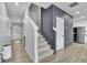 Hallway with wood-look floors leading to staircase with a gray accent wall and white trim at 1386 Ben Park Way, Grayson, GA 30017