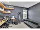 Well-lit home office with a comfortable gray sofa and custom wood shelving at 1386 Ben Park Way, Grayson, GA 30017