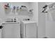 Well-lit laundry room with modern washer and dryer, overhead shelving, and ample storage space at 1386 Ben Park Way, Grayson, GA 30017