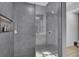 Modern shower with gray tile, a glass enclosure, a rain shower head, and built in shelving at 1386 Ben Park Way, Grayson, GA 30017