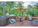 Outdoor deck featuring an umbrella-covered dining table, a grill, and scenic views surrounded by mature trees at 2604 Porchside Se Pl, Atlanta, GA 30316
