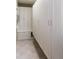 Bright laundry room with ample storage space in the white built-in cabinets and neutral-toned tile flooring at 2604 Porchside Se Pl, Atlanta, GA 30316