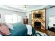 Stylish main bedroom featuring a decorative fireplace wall, ceiling fan, a king bed, and lots of natural light at 2604 Porchside Se Pl, Atlanta, GA 30316