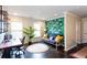 Bright home office with hardwood floors, a modern desk, futon, and a vibrant leaf-patterned accent wall at 2604 Porchside Se Pl, Atlanta, GA 30316