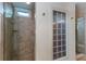 Beautifully tiled shower with glass door, convenient shelving, and natural light from a glass block window at 2604 Porchside Se Pl, Atlanta, GA 30316