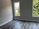 Bedroom with luxury vinyl plank flooring and views from two windows of trees and greenery at 43 Wickford Way, Villa Rica, GA 30180