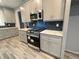 Kitchen featuring stainless steel range and microwave paired with grey cabinets and backsplash at 43 Wickford Way, Villa Rica, GA 30180