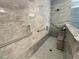 Barrier free shower with gray marble-style tile, a built-in seat, and brushed nickel grab bars at 43 Wickford Way, Villa Rica, GA 30180