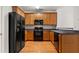 Kitchen featuring stainless steel appliances, wood cabinets, and a black refrigerator at 4370 Stone Gate Way # 97, Atlanta, GA 30344