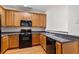 Kitchen featuring stainless steel sink, black appliances, and wood cabinets at 4370 Stone Gate Way # 97, Atlanta, GA 30344