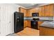 A kitchen featuring wood cabinets, black appliances, and hardwood floors at 4370 Stone Gate Way # 97, Atlanta, GA 30344