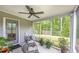 Covered outdoor patio with gray concrete floor, outdoor seating, ceiling fan, and a green lawn view at 448 Marston Pass, Acworth, GA 30102