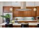 Modern kitchen design features warm cabinets, a center island and a stainless steel hood vent at 1058 Piedmont Ave # 103, Atlanta, GA 30309
