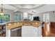 Close up on kitchen island, granite countertop, stainless steel dishwasher, and open concept living room at 338 Santa Anita Ave, Woodstock, GA 30189