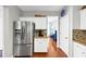 View of kitchen, stainless steel fridge, beautiful hardwood floors and view into dining room at 338 Santa Anita Ave, Woodstock, GA 30189