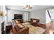 Cozy living room with hardwood floors, fireplace, ceiling fan, and comfortable leather furniture at 338 Santa Anita Ave, Woodstock, GA 30189