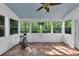 Bright sunroom features tile floor, a ceiling fan, and multiple windows showcasing the backyard views at 338 Santa Anita Ave, Woodstock, GA 30189