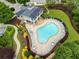 Aerial view of a pool with lounge chairs, patio area, and a clubhouse surrounded by lush landscaping and mature trees at 3788 Chattahoochee Summit Se Dr # 22, Atlanta, GA 30339