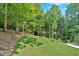 A beautifully sloped backyard with fresh cut green grass and a view of the woods at 507 Karen Ln, Woodstock, GA 30188