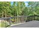 A wooden deck with black railings overlooking a lush green forest at 507 Karen Ln, Woodstock, GA 30188